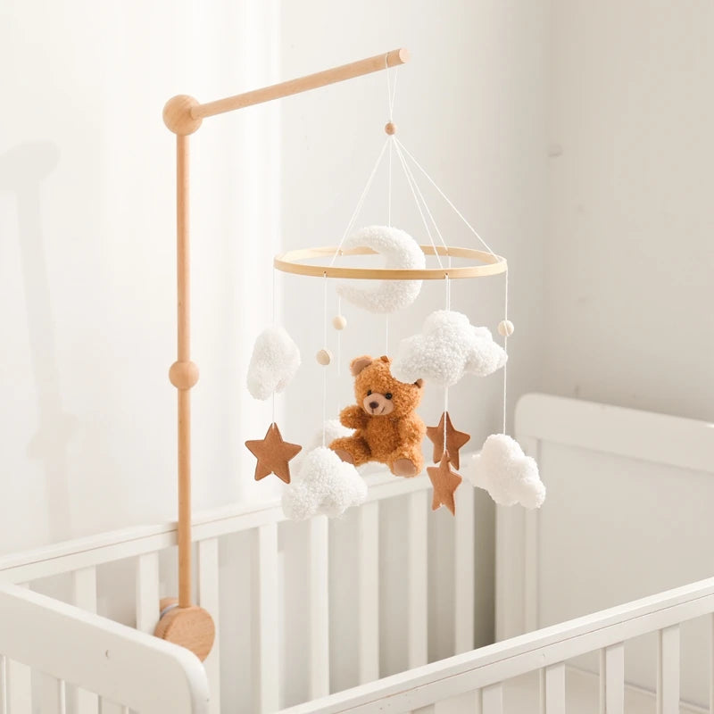 Baby crib with a mobile featuring a teddy bear and stars