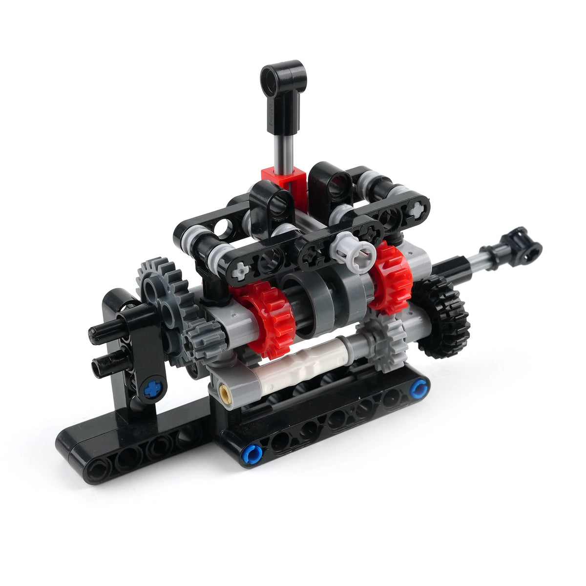 A toy construction set model featuring black, gray, and red gears, levers, and a metal tube assembly on a white background.