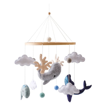 Children's mobile with whale, fish, and cloud designs on a white background