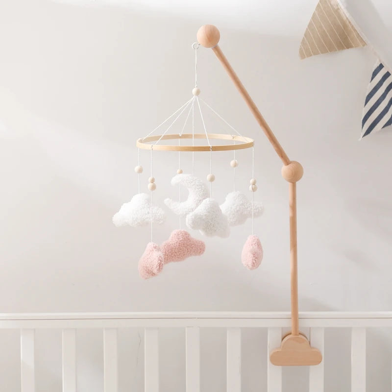 Baby mobile with clouds and stars hanging above a crib in a nursery.
