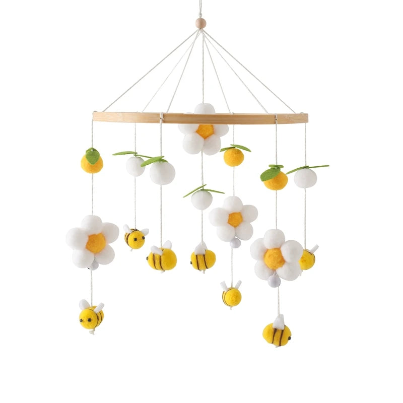 Children's mobile with flowers and bees hanging from a wooden rod on a white background