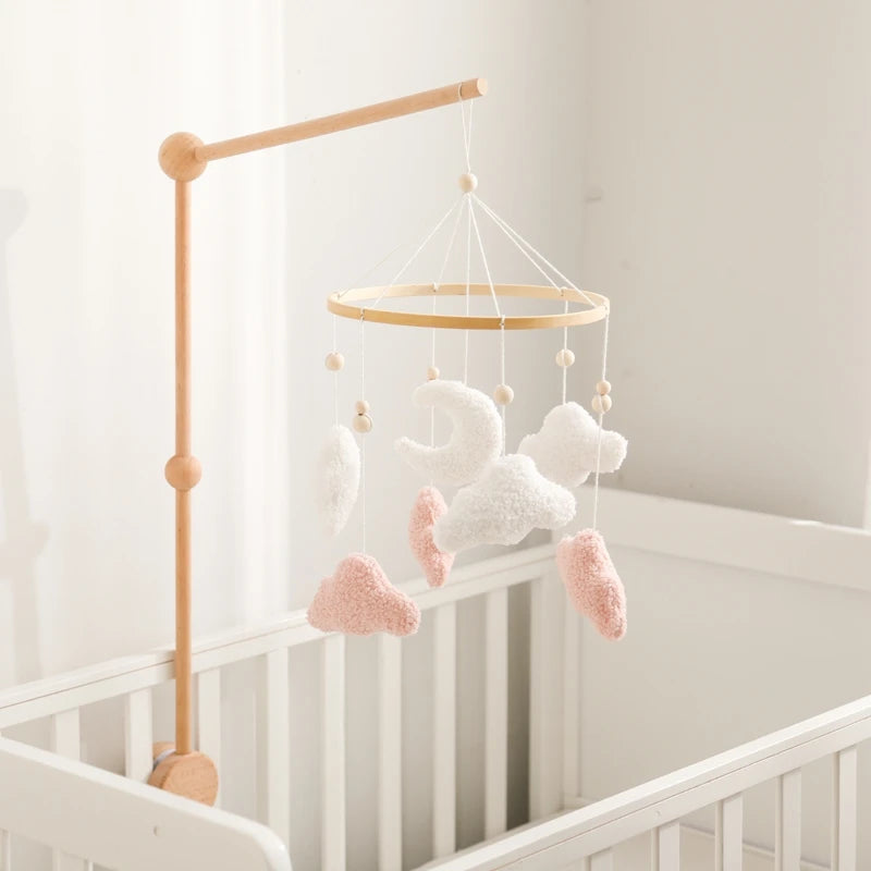 Baby crib mobile with clouds and stars hanging over a crib