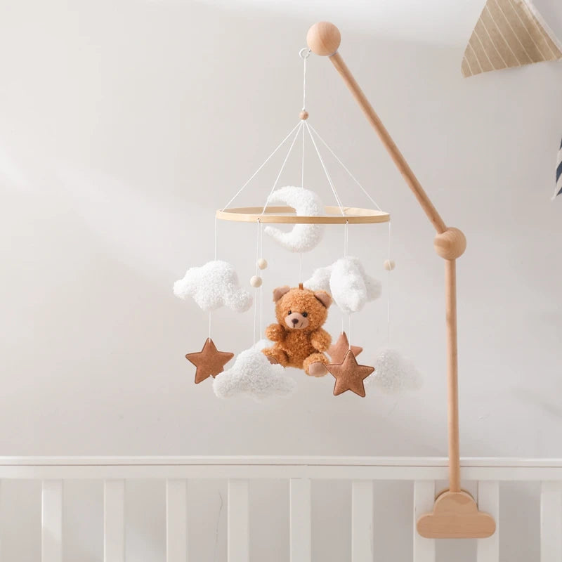 Baby mobile with teddy bear and stars hanging above a crib