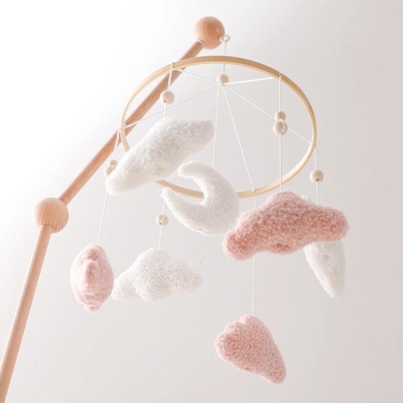 Baby mobile with cloud-shaped hanging objects on a light background