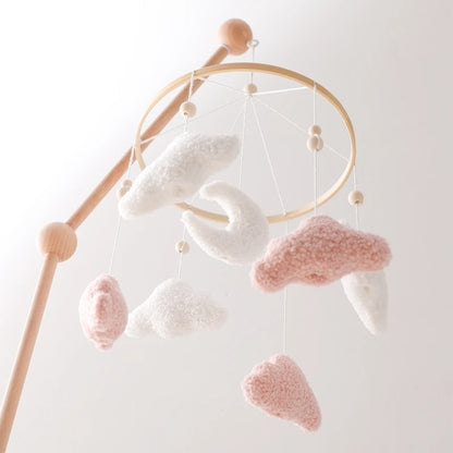 Baby mobile with cloud-shaped hanging objects on a light background