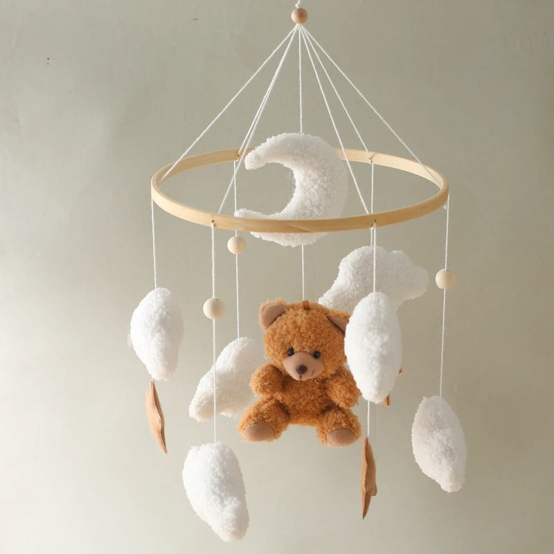 Baby mobile with teddy bear and clouds on a plain background