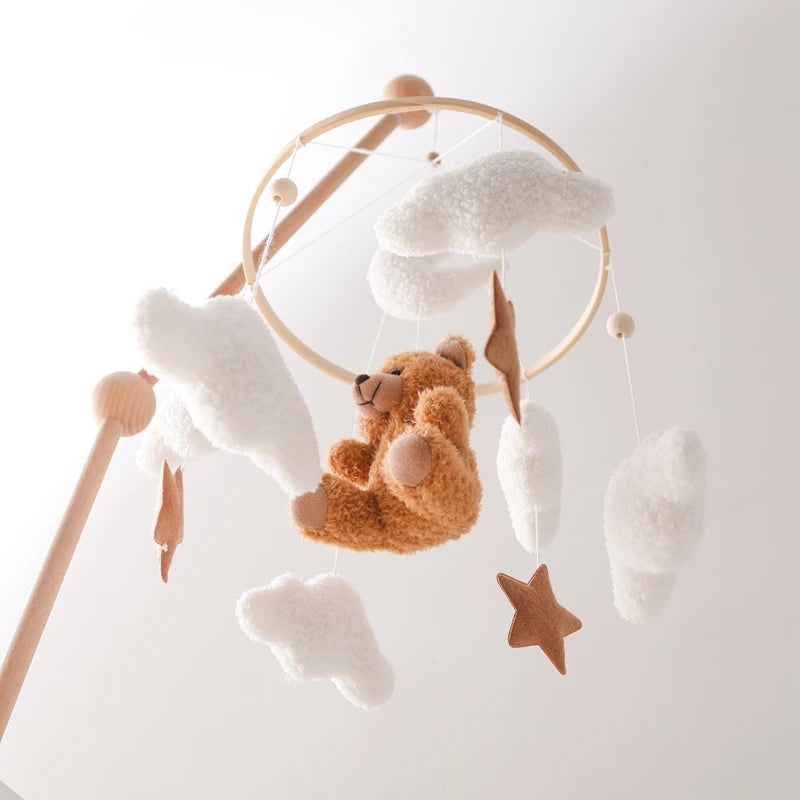 Baby mobile with teddy bear and cloud decorations on a white background