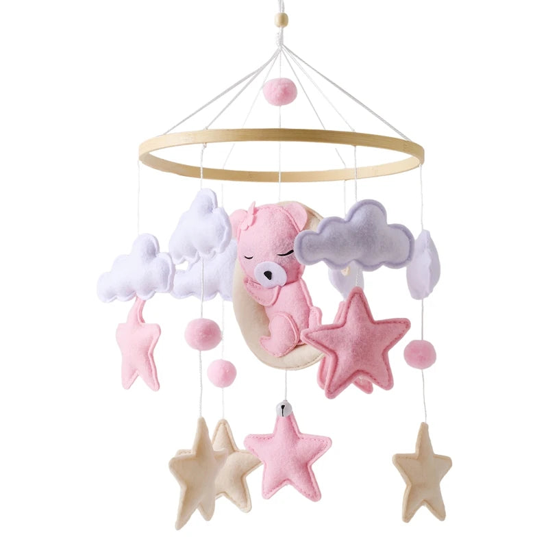 Baby crib mobile with pink bear, stars, and clouds on a white background