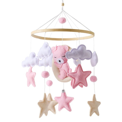 Baby crib mobile with pink bear, stars, and clouds on a white background