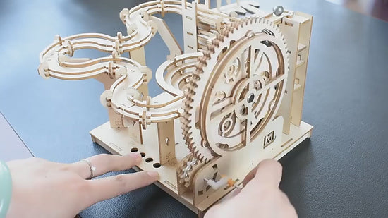 Wooden marble run kit demonstrating the manual crank and mechanical marble track
