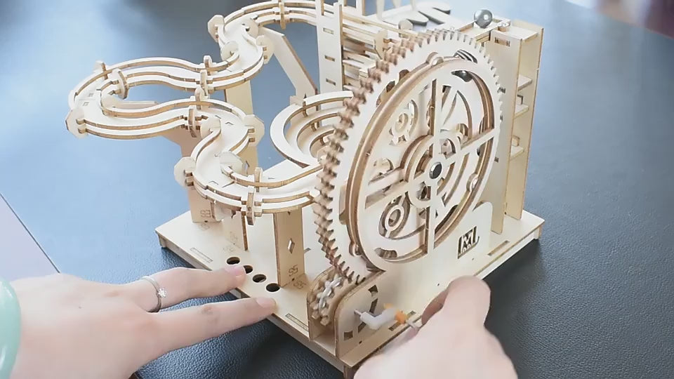 Wooden marble run kit demonstrating the manual crank and mechanical marble track