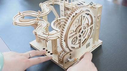 Wooden marble run kit demonstrating the manual crank and mechanical marble track