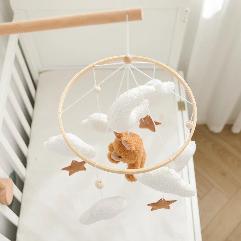 Baby crib with a mobile featuring a teddy bear and stars