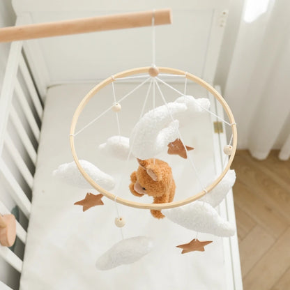 Baby crib with a mobile featuring a teddy bear and stars