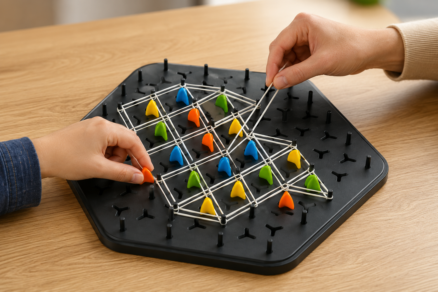 Close-up of players stretching elastic bands and claiming triangles while playing the TriLogic™ Strategy Board Game.