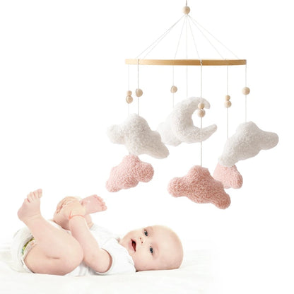 Baby mobile with clouds and stars hanging above a baby