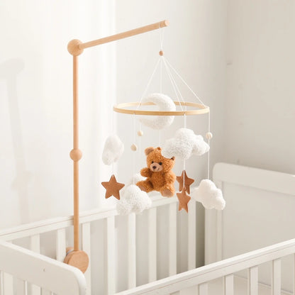 Baby crib with a mobile featuring a teddy bear and stars
