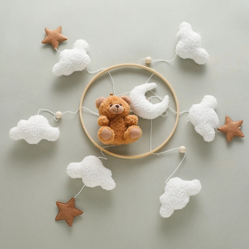 Decorative wall hanging with teddy bear, clouds, and stars on a light gray background
