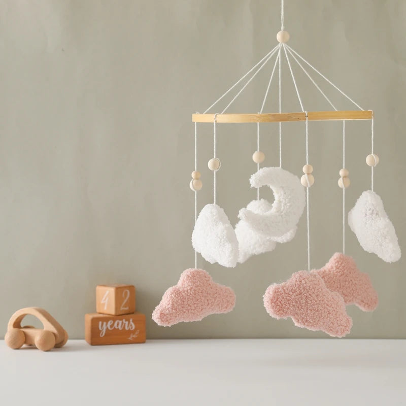 Baby mobile with fluffy clouds hanging against a neutral background