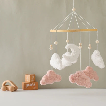 Baby mobile with fluffy clouds hanging against a neutral background